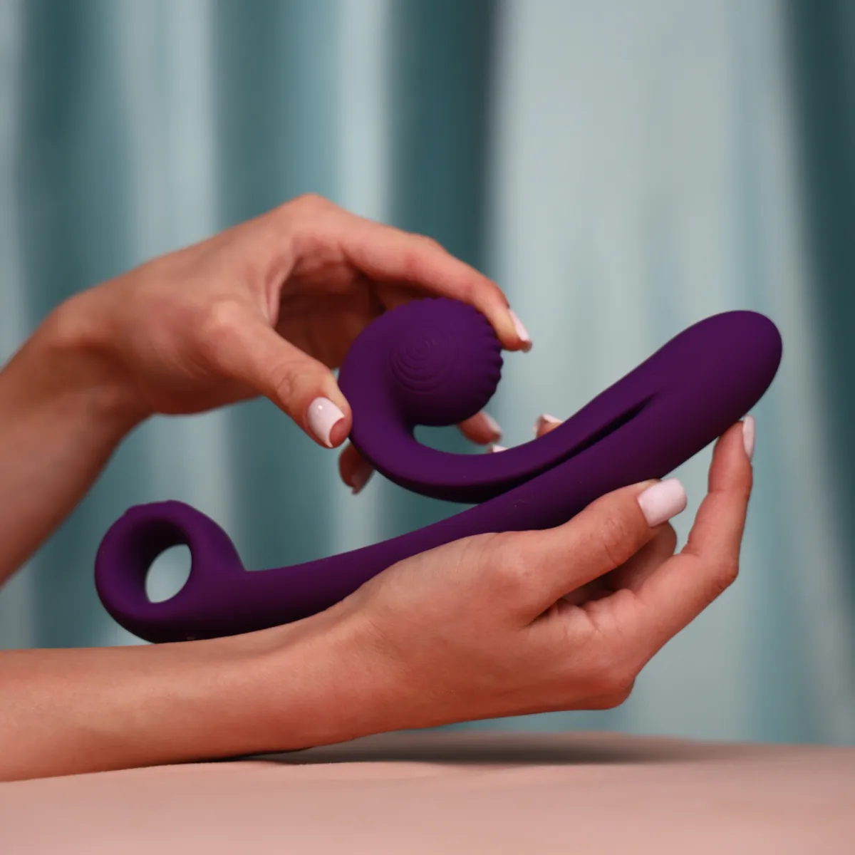 Manos sosteniendo Snail Curve morado en una fotografía oficial de SVibe